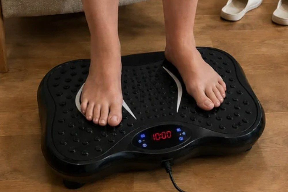 Kvinna står barfota på Vera FIT vibrationsplatta