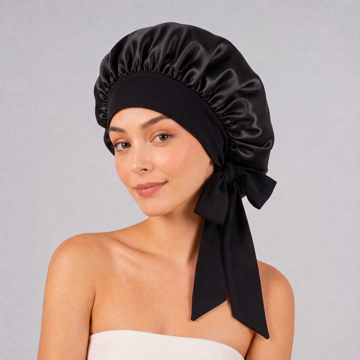 Kvinna med svart silk bonnet i mullbärssilke på håret - silkesmössa att sova i