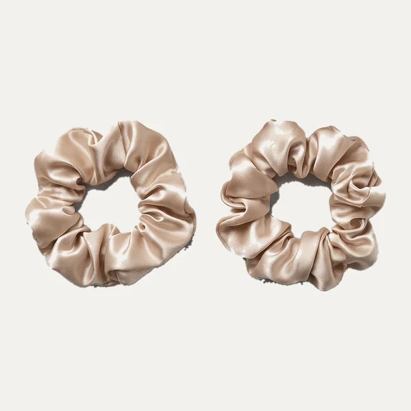 Två scrunchies som fäster lockbandet i håret